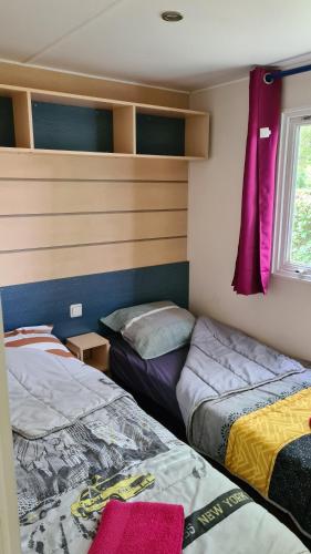 a room with two beds and a window at Mobil-Home 1à 4 Personnes in Attigny