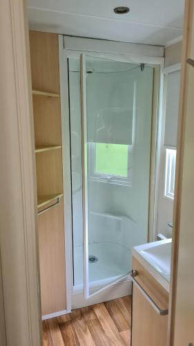 a bathroom with a glass shower in a room at Mobil-Home 1à 4 Personnes in Attigny