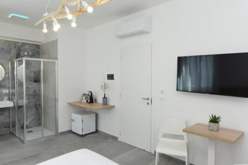 a living room with a tv and a white wall at Luna Calante in Santa Maria di Castellabate