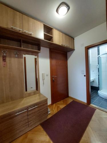 a kitchen with wooden cabinets and a large mirror at Apartmani IVANA in Vrnjačka Banja
