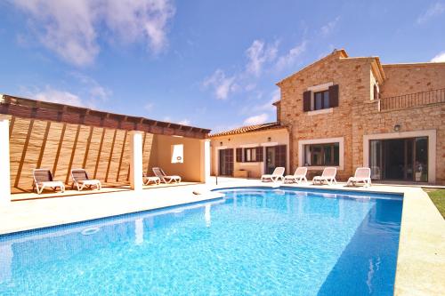 a swimming pool in front of a house at New, Premium Finca mit Starlight-Pool! South-East Coast in S'Horta