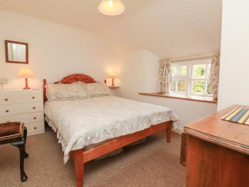um quarto com uma cama, uma secretária e uma janela em Damson Cottage em Bridgwater