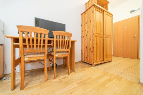 mesa de comedor con 2 sillas y armario en Ośrodek Wrzosowa Góra - pokoje en Ruciane-Nida