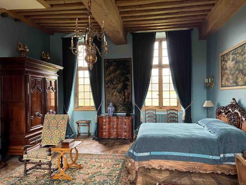 a bedroom with blue walls and a bed and a chair at Château de La Rivière in Pontgouin