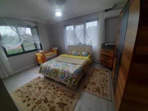 een slaapkamer met een bed, een dressoir en ramen bij Müstakil villa in Trabzon