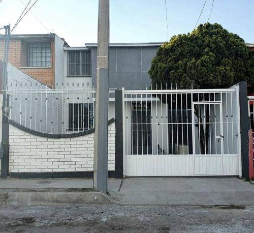 a white fence in front of a house at Depto San Angel 4, Planta alta, Cd Juarez Chih Mex in Ciudad Juárez