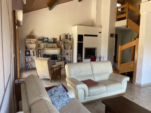 un salon avec un canapé et une chaise dans l'établissement Saint-Jorioz Maison , vue montagnes, jardin clos , 8pers, à Saint-Jorioz