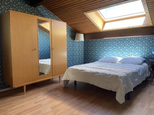 sypialnia z łóżkiem i komodą z lustrem w obiekcie Saint-Jorioz Maison , vue montagnes, jardin clos , 8pers w mieście Saint-Jorioz