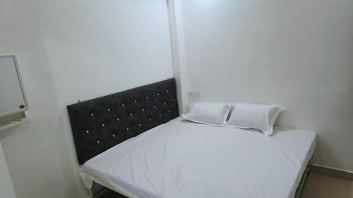 ジャバルプルにあるHotel 100 Meterの小さなベッド(白い枕2つ付)