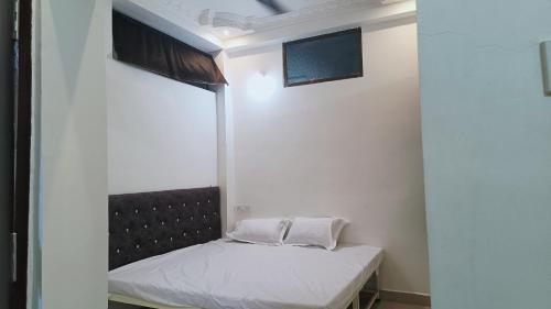 a small room with a bed and a window at Hotel 100 Meter in Jabalpur