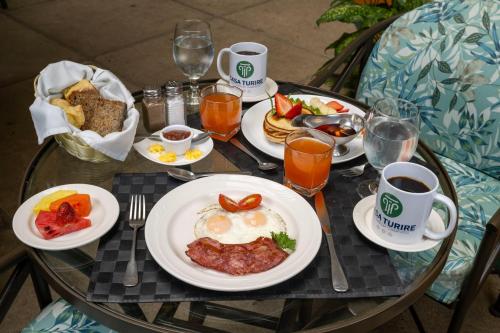 a table with plates of food and cups of coffee at Hotel Casa Turire in Turrialba