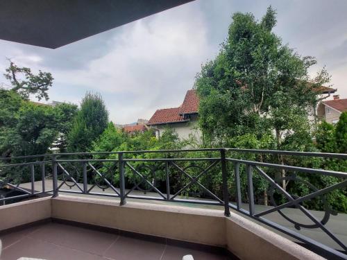 a balcony with a railing and trees at Apartmani IVANA in Vrnjačka Banja