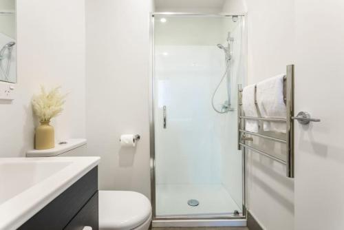 y baño con ducha, aseo y lavamanos. en Cosy Studio in Central Avondale - Netflix Wi-Fi en Auckland