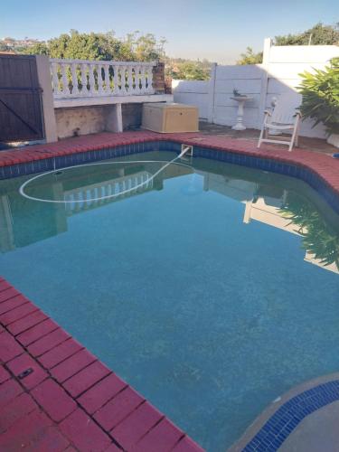 a swimming pool with blue water in a backyard at Busis guesthouse in Durban