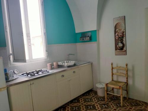 a small kitchen with a stove and a window at Suite San Giovanni in Torre Santa Susanna
