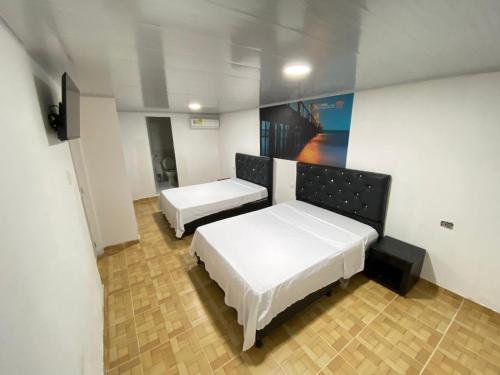 Cette chambre comprend deux lits et un tableau mural. dans l'établissement Apartahotel Saroa, à Fonseca