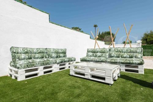 two couches and a coffee table on a lawn at Villa with private heated Pool by the beach & port - Benalmadena by REMS in Benalmádena