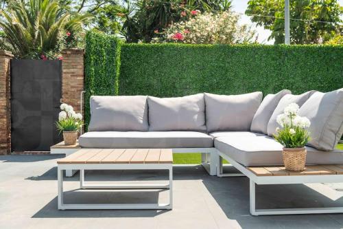 a patio with a white couch and a coffee table at Villa with private heated Pool by the beach & port - Benalmadena by REMS in Benalmádena