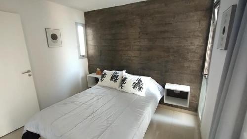 1 dormitorio con 1 cama blanca grande y 2 almohadas en Marcos Paz 100 en San Miguel de Tucumán
