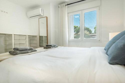 a large white bed in a white room with a window at Villa with private heated Pool by the beach & port - Benalmadena by REMS in Benalmádena