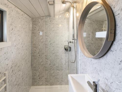 La salle de bains est pourvue d'une douche, d'un lavabo et d'un miroir. dans l'établissement Greenacres Carriage, à Maybole