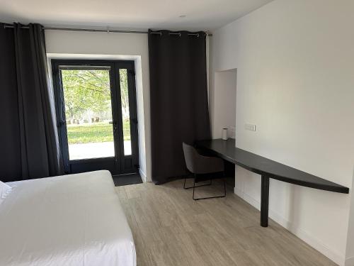 - une chambre avec un lit, un bureau et une fenêtre dans l'établissement Hameau Les Gaties, à Saint-Germain-des-Champs