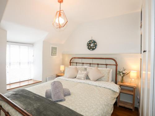 a bedroom with a large bed and a window at Bwthyn Lili Lily Cottage in Cemaes Bay