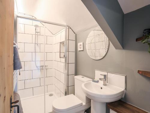 a bathroom with a sink and a toilet and a shower at Bwthyn Lili Lily Cottage in Cemaes Bay