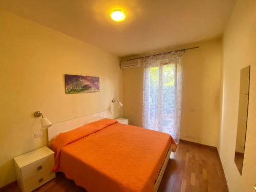 um quarto com uma cama laranja e uma janela em Casetta, 54 em Sirolo