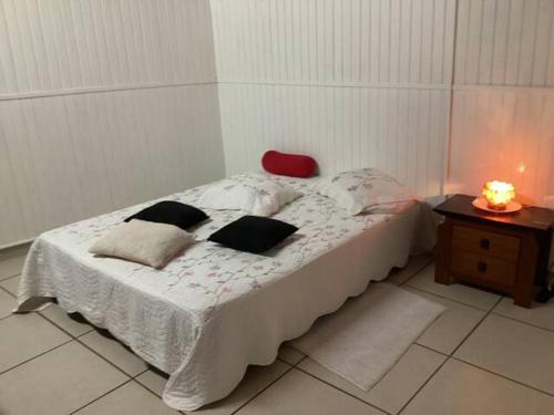 1 dormitorio con 1 cama con silla roja y mesa en Appartement dans propriété reposante, en Saint-Benoît