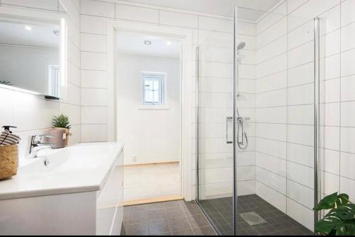 baño blanco con ducha y lavamanos en Oslo airport 15 en Nannestad
