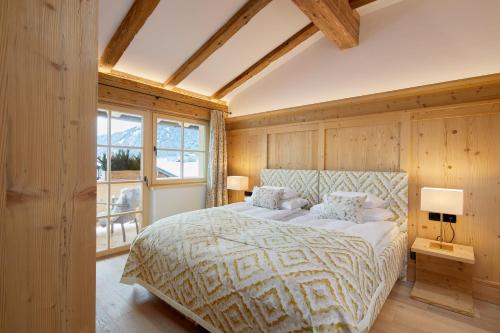 a bedroom with a large bed with wooden walls at Tennerhof Luxury Chalets in Kitzbühel