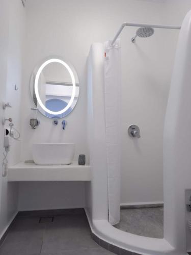 a white bathroom with a sink and a mirror at Shape-Infinity in Kalymnos
