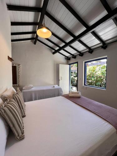 a large bedroom with two beds and a window at Casa deck Caraíva in Caraíva
