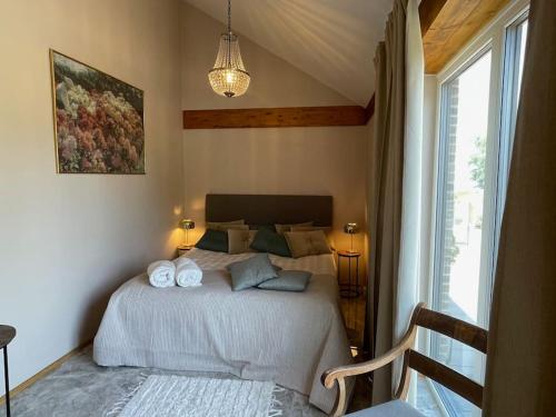 a bedroom with a bed with two towels on it at Luksus hus i 1st række, all-incl top komfort med SPA og skov in Strøby