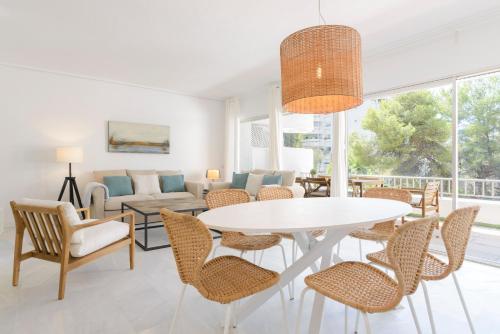 マルベーリャにあるJardines del Mar Apartmentsのリビングルーム(白いテーブル、椅子付)