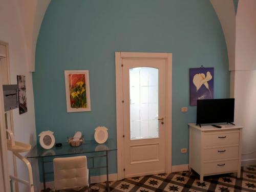 a room with a desk and a door with a television at Suite San Giovanni in Torre Santa Susanna