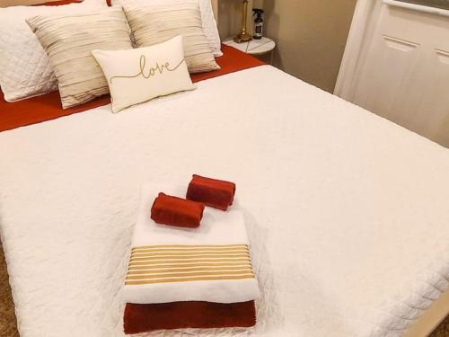 a white bed with two towels on top of it at Romance in the City 1 Bdrm Studio in Downtown St Pete in St Petersburg