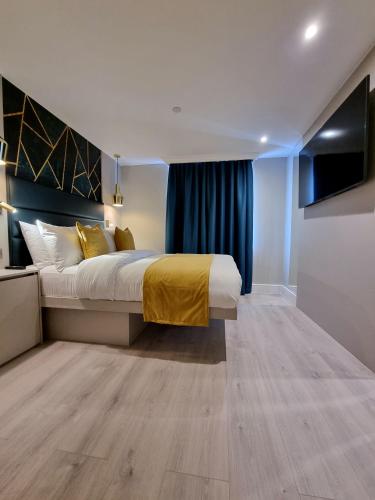 a bedroom with a large bed with a yellow blanket at NOX Kensington Gardens in London