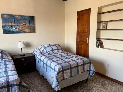a small bedroom with a bed and a door at Casa Stella Centro Histórico in Guatemala