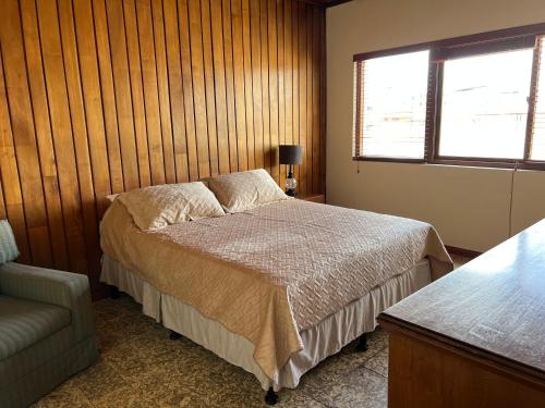 ein Schlafzimmer mit einem Bett, einem Stuhl und einem Fenster in der Unterkunft Casa Stella Centro Histórico in Guatemala