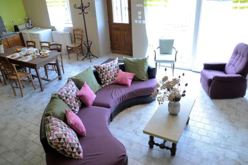 un salon avec un canapé violet et une table dans l'établissement GRAND LOGIS DES CHOUETTES, 5 chambres, proche de Verdun et ses sites de la grande guerre, à Châtillon-sous-les-Côtes