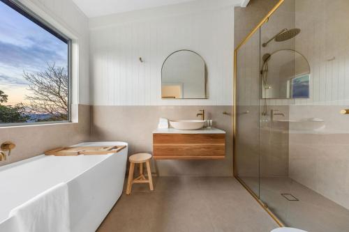 y baño con bañera, lavabo y espejo. en Mountain Retreat with ocean views, en Kin Kin
