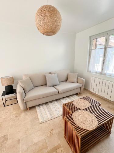 a living room with a couch and a table at L'Orée des Vignes - Maison Cosy avec Jardin Clos in Molosmes