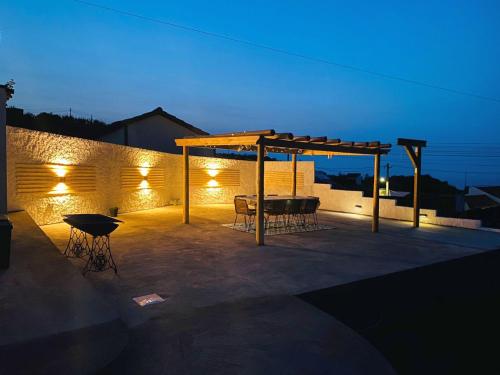 a patio with a table and a canopy at night at Casa da Fonte - Alojamento Local com Jacuzzi in Nordeste