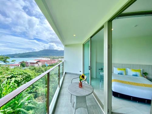 una camera da letto con un letto e un tavolo sul balcone di Oceana Sea View - Kamala Beach a Kamala Beach