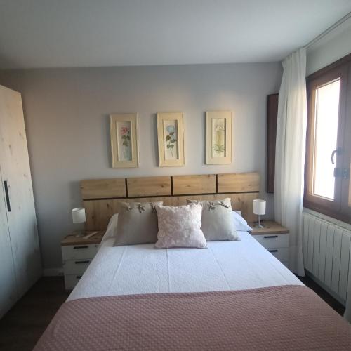 a bedroom with a large bed with two tables and a window at Rincón Gótico in Burgos
