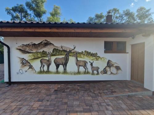 a mural of deer on the side of a building at Villa Garden in Bešeňová