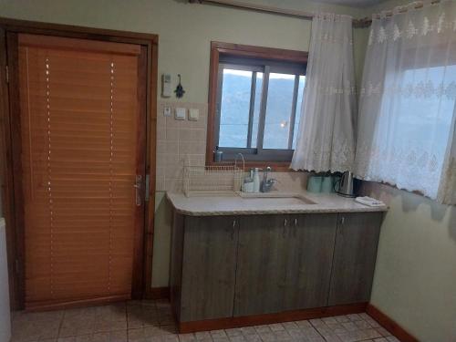 een badkamer met een wastafel en een raam bij בקתות קסם חרמון in Nimrod