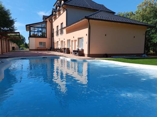 a swimming pool in front of a house at Navigator in Palić